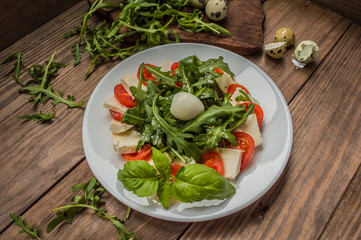 Arugula Salad - Caprese . Wooden background. Top view. Close-up