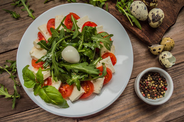 Arugula Salad - Caprese . Wooden background. Top view. Close-up