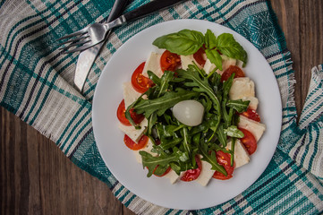 Arugula Salad - Caprese . Wooden background. Top view. Close-up