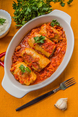 Dinner with cabbage rolls in tomato sauce decorated  parsley. Wooden blue rustic background. Top view. Close-up