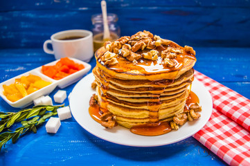 Pancakes with walnuts and maple syrup for breakfast. Close-up