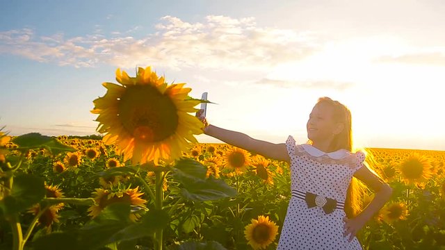 young girl taking pictures in field of sunflowers phone online photo girls on sunflower background