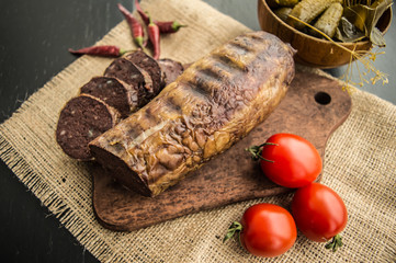 Homemade blood sausage with offal on a black wooden background. Top view. Close-up
