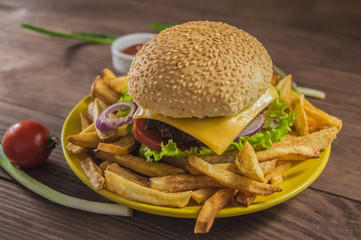 Big sandwich - hamburger burger with beef, cheese, tomato. On a wooden rustic background. Close-up