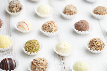 Chocolate truffle candies on white wooden background