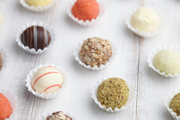 Chocolate truffle candies on white wooden background