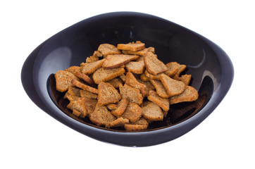 bread gray salty croutons on a black a plate on white background
