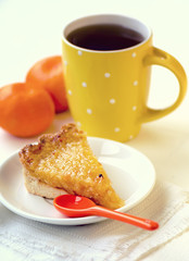 Lemon and orange tart with tea and tangerines on white background