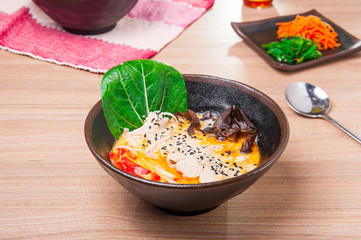 Curried Noodle Soup with coconut milk, grilled chicken, wood mushrooms, sprouts, decorated  sesame seeds