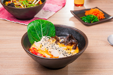 Curried Noodle Soup with coconut milk, grilled chicken, wood mushrooms, sprouts, decorated with sesame seeds
