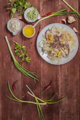 Octopus with Chinese cabbage in soya sauce. At the rustic wooden background. Top view. Close-up
