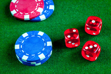 poker chips and dice on green background top view