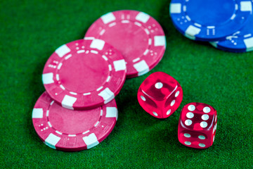 poker chips and dice on green background top view