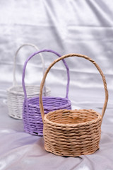 Fototapeta na wymiar Woven baskets for flower arrangements on the white satin