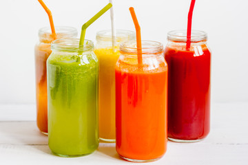 Fresh detox juices in glass bottles on white background