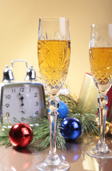 Glass of sparkling shampagne wine Clock and gift box on christmas background