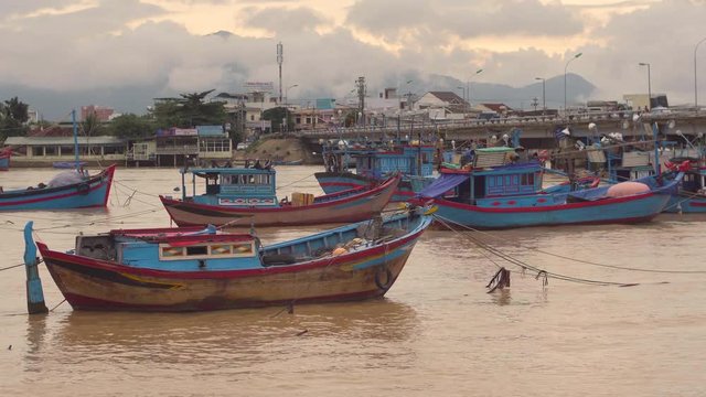 Vietnamese boats on a river at sunset. Busy bridge with lots of motorbikes. Nha Trang, Vietnam travel landscape and destinations.