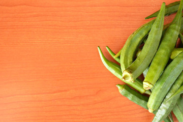 Okra, Lady’s finger, Gombo, Gumbo, Bendee, Quimbamto's seed on the old wooden