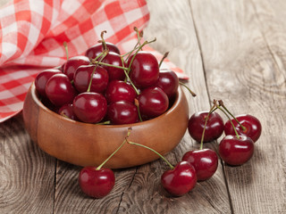 Ripe cherries on old wooden board.