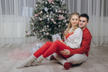 Obraz na płótnie Canvas loving couple decorating Christmas tree