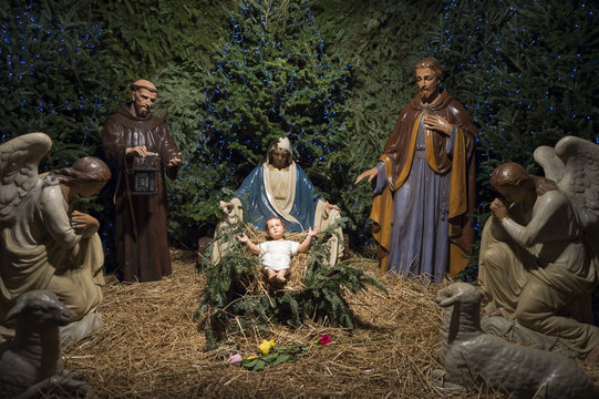 Christmas nativity scene with Mary, Joseph, and the Angel Gabriel looking down on baby Jesus in his manger