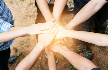 Posting back hand to the center of group of people in circle to