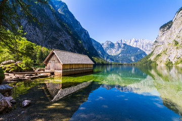 Fototapeta na wymiar Boat dock hangar on Obersee mountain lake in Alps. Bavaria, Germany