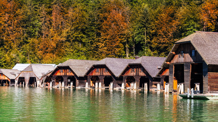 Fototapeta na wymiar Timber boathouses or sheds by the lake. South of Berchtesgaden. Starting point for lake cruises. Konigssee. Germany.