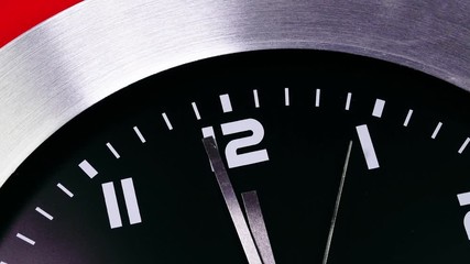 Clock counting down last seconds to the New year on a mechanical clock. Twelve o'Clock on New Year's Eve. Face of a clock indicating midnight. Last minute till New Year,midnight, Red background. - Powered by Adobe