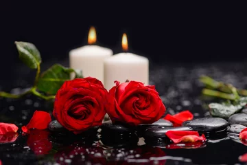 Fototapeten Zwei rote Rose mit Kerze, grünem Blatt und Therapiesteinen © Mee Ting