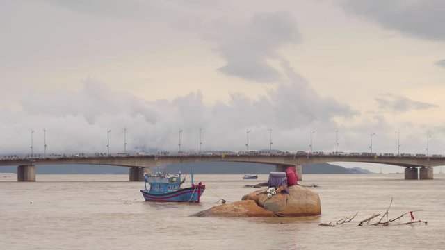 Vietnamese boat on a river at sunset. Little rock in water. Nha Trang, Vietnam travel landscape and destinations.