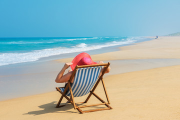 Happy woman  in red sunhat on the beach