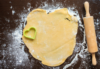 Roll out the dough on a black table. The dough is squeezed out i