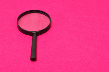 Magnifying glass isolated on a pink background