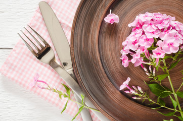 Obraz na płótnie Canvas Spring table settings with fresh flower, napkin and silverware.