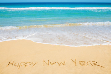 Fototapeta na wymiar Happy New Year message on the beach