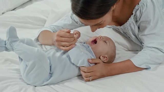 Happy young mother giving Eskimo kisses to infant son 