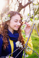Fototapeta premium happy young woman near a flowering tree in the Park