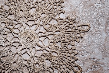 Handmade crocheted doily with grey cotton threads on a neutral g - obrazy, fototapety, plakaty
