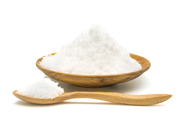 White salt in wooden plate and wooden spoon