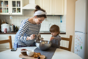 Obraz na płótnie Canvas young pregnant mother with son Toddler, make dough for baking
