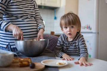 young pregnant mother   with son Toddler, make  dough for baking