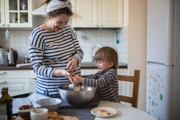 Obraz na płótnie Canvas fun young pregnant mother with son Toddler, make dough for ba