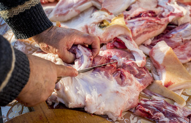 Butcher chopping pig meat in a rural scene