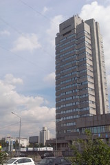 Modern tower against the sky with clouds. The gray building.