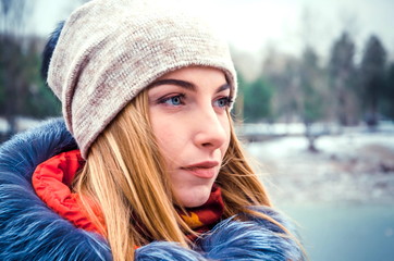 Christmas girl outdoor portrait. Winter woman blowing snow in park. Flying Snowflakes.  Beauty young woman Having Fun in Winter Park. Good mood. girl in bright winter clothes
