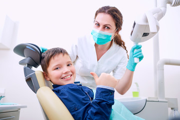 Child with doctor in the office shows thumb .