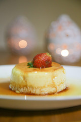 Homemade creme caramel served with sweet syrup and strawberry