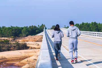smart couple running on bridge. Healthy lifestyle love couple of cardio together in outdoors.
