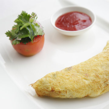 Eggs omlette served with tomato
